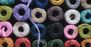 A grid of colorful yarn balls in many shades viewed from above, a crafter's yarn stash